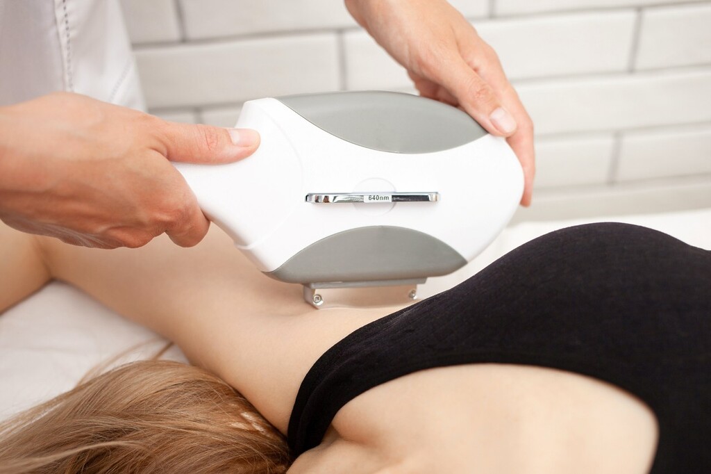 aesthetic practitioner removes hair from a client's armpit using laser