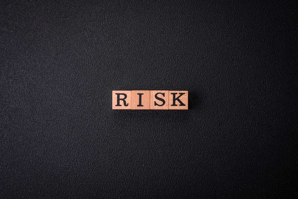 
The inscription Risk made of wooden cubes on a plain black background