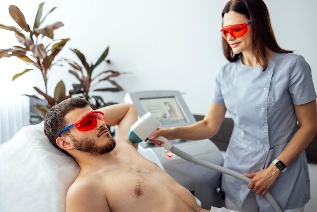 man receiving photo epilation while visiting an aesthetic clinic